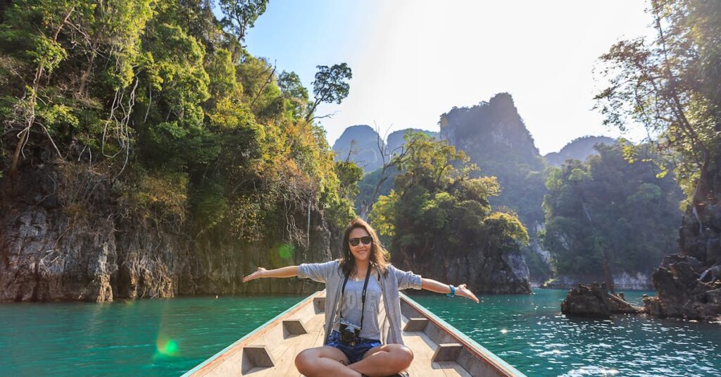 Asian woman relishing a serene boat journey through the lush karst landscape of Thailand's Khlong Sok.